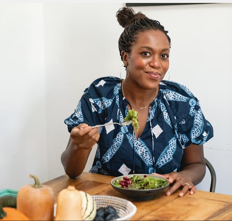 Maya Feller at the table with a fresh salad